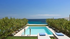foto poolblick mit sonnenliegen und meeres ausblick an den seiten blumen und pflanzen der ozean ist azur blau der blick vom luxuriösen hochklassigen exklusiven designer hotel santa marina auf mykonos in griechenland europa